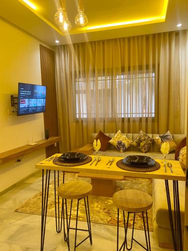 a living room with a table and a couch at Élégance en 40 mètres Nouaceur in Nouaceur