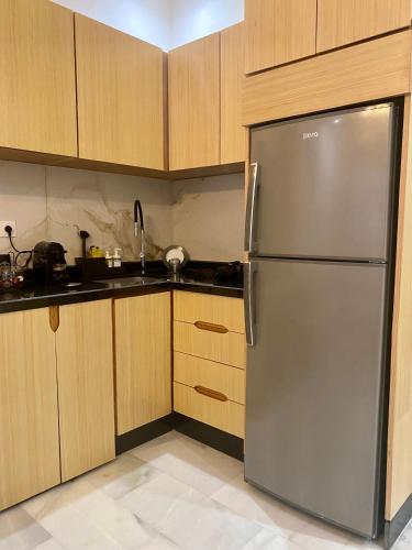 a stainless steel refrigerator in a kitchen with wooden cabinets at Élégance en 40 mètres Nouaceur in Nouaceur