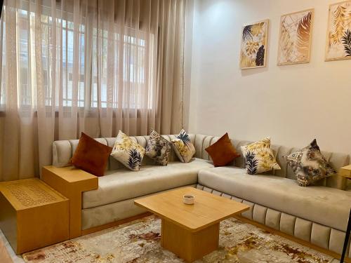 uma sala de estar com um sofá e uma mesa em Élégance en 40 mètres Nouaceur em Nouaceur