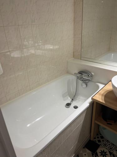 une baignoire blanche dans une salle de bain avec un miroir dans l'établissement Mes vacances à la montagne, à Villarembert