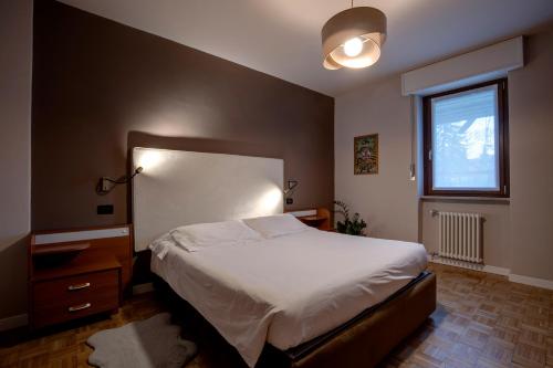 une chambre avec un grand lit et une fenêtre dans l'établissement 203 Aosta Apartment, à Aoste