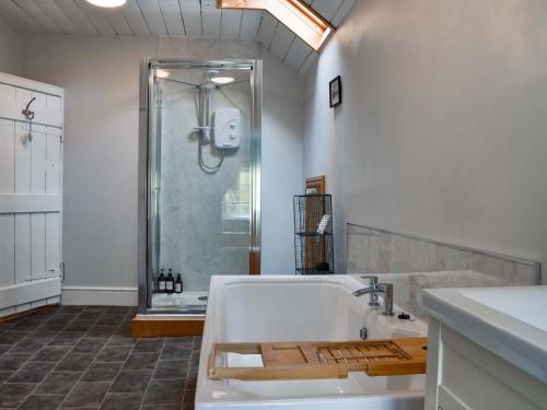 a bathroom with a shower and a white tub at Lower Farm in Llanfihangel Rhydithon