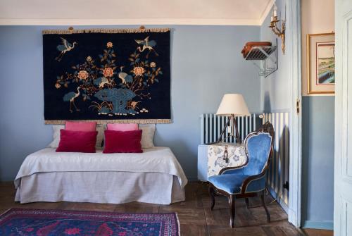 ein blaues Schlafzimmer mit einem Bett und einem blauen Stuhl in der Unterkunft Colazione in Piazza Castello in Turin
