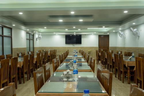 a conference room with tables and chairs and a flat screen tv at Hotel Akbar At Dal Lake Ghat Number 1 in Srinagar