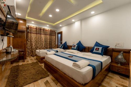 a bedroom with two beds with blue and white pillows at Hotel Akbar At Dal Lake Ghat Number 1 in Srinagar