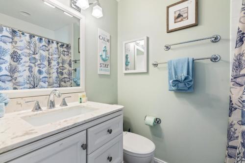 een badkamer met een wastafel, een toilet en een spiegel bij The Redington Beach House in St Pete Beach