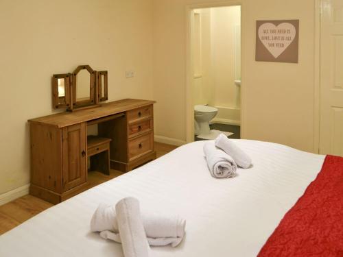 a bedroom with a bed and a dresser and a mirror at Rose Cottage - Uk3283 in Guyzance