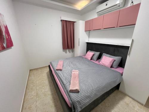 a small bedroom with a bed with pink pillows at Selena Bay Hurghada - Pink Apartment in Hurghada