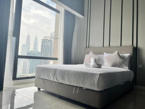 a bed with a teddy bear sitting on it in front of a window at Axon Bukit Bintang By moonlight in Kuala Lumpur