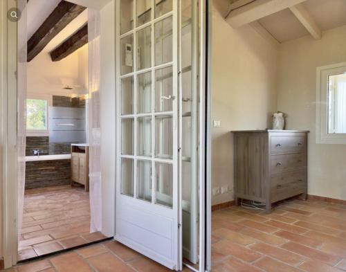 Una puerta giratoria en una habitación con cocina en Villa Ormarine, vue exceptionnelle sur la baie de Cannes et le Mercantour en Les Adrets de l'Esterel