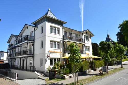 a white building with a black roof at Pension Sanddorn mit Café Carlssons in Binz