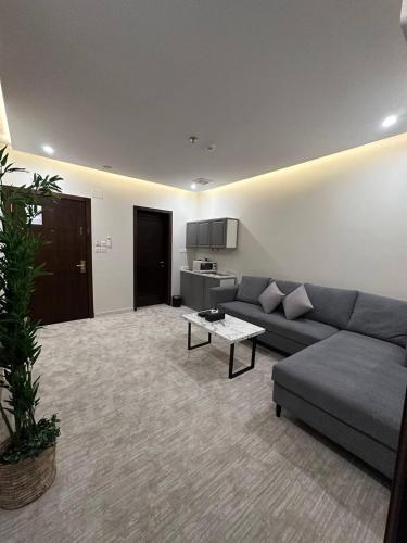 a living room with a couch and a table at بارك المدينة للشقق المخدومة in Al Madinah