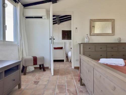 a bedroom with a bed and a table and a mirror at Villa Ormarine, vue exceptionnelle sur la baie de Cannes et le Mercantour in Les Adrets de l'Esterel