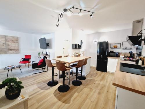 eine Küche und ein Wohnzimmer mit einem Tisch und Stühlen in der Unterkunft Appartement 3 salles de bains 3 chambres 6 personnes in Limoges