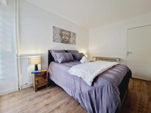 um quarto com uma cama e uma mesa com um candeeiro em Appartement 3 salles de bains 3 chambres 6 personnes em Limoges