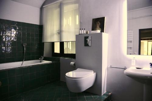y baño con aseo blanco y lavamanos. en La Suite de la Bastide, en Val-de-Dagne