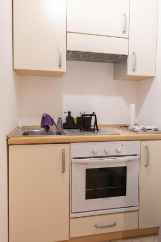 a kitchen with white cabinets and an oven at Dimora Artale in Cattedrale in Palermo