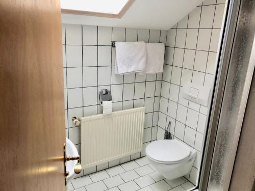 a bathroom with a toilet and towels on the wall at Pension Margaretenhof in Bayerbach