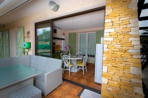 d'une terrasse avec une table et un mur en pierre. dans l'établissement GITE HISTOIRE DE FAMILLE, à Aubagne