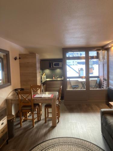 une cuisine et un salon avec une table et des chaises dans l'établissement Appartement Brides Confort, à Brides-les-Bains