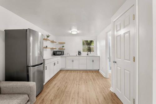 uma cozinha com um frigorífico de aço inoxidável e armários brancos em Modern Loft Carriage House em Decatur