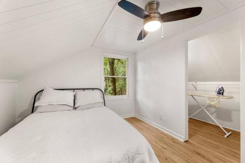 um quarto branco com uma cama e uma ventoinha de tecto em Modern Loft Carriage House em Decatur
