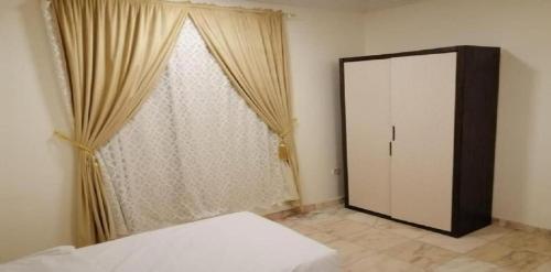a bedroom with a bed and a window with curtains at حياة ريف للوحدات السكنية المفروشة in Jeddah
