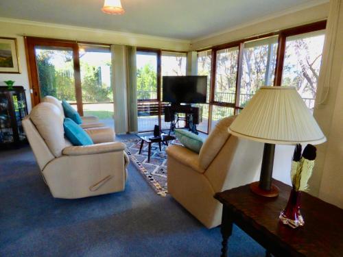 una sala de estar con 2 sillas y una lámpara. en Bluff House, en St Leonards