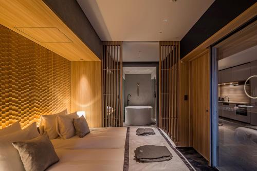 a bedroom with a large bed and a bathroom at MUWA NISEKO in Kutchan