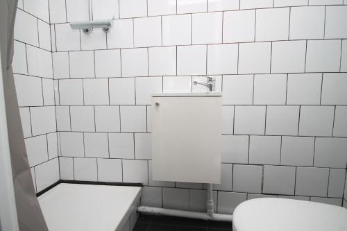 a white tiled bathroom with a toilet and a sink at 04 - Chambre avec lit double proche Paris et transports WIFI in Saint-Denis