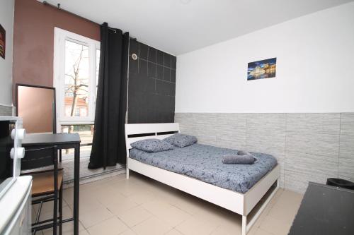 a small bedroom with a bed and a desk at 04 - Chambre avec lit double proche Paris et transports WIFI in Saint-Denis