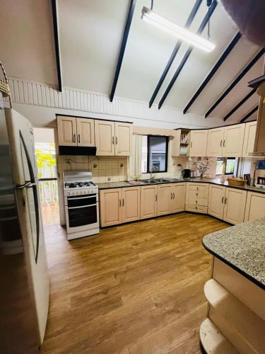 a large kitchen with white appliances and wooden floors at Island Accommodation Suva Premier Hospitality in Suva