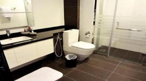 uma casa de banho com um WC, um lavatório e um chuveiro em TIME Royal Ambassador Hotel em Harbel