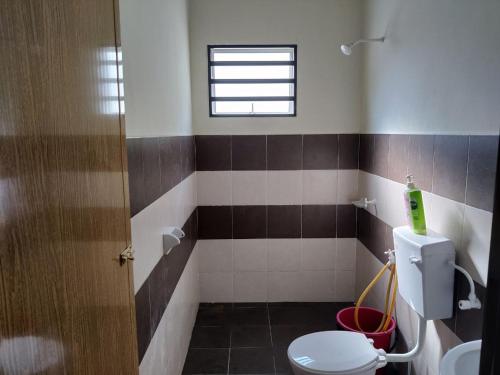 baño con aseo y ventana en Just Homestay en Sitiawan