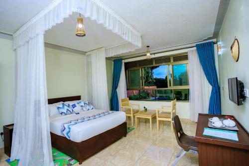 una camera con letto, scrivania e di Victoria View Boutique Hotels Kigo a Entebbe