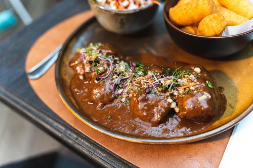 a plate of food with meat and a bowl of chips at Maison de la Paix in Poperinge
