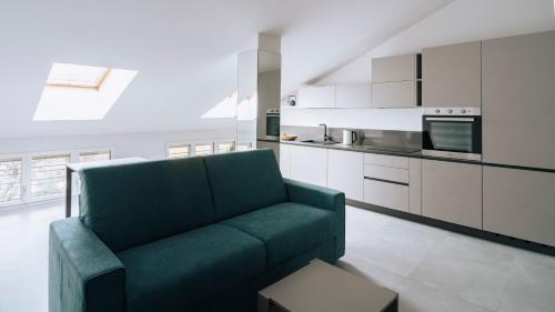 a living room with a green couch in a kitchen at Aosta Holiday Apartments - Monte Solarolo in Aosta