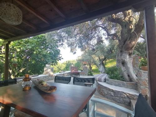 a table and chairs on a patio with a tree at kalivi in Skiathos Town