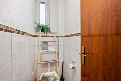 ein Badezimmer mit WC und eine Pflanze auf einem Regal in der Unterkunft Sali Homes - Heilbronn Süd in Heilbronn