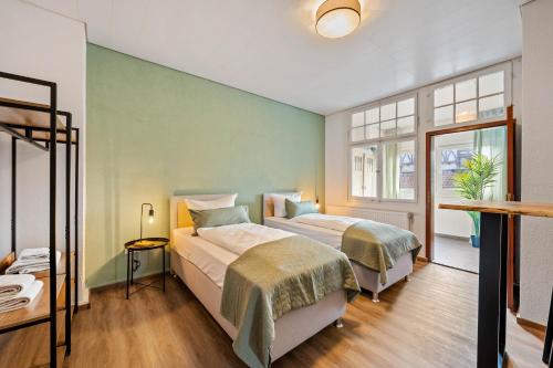 2 Betten in einem Zimmer mit grünen Wänden in der Unterkunft Sali Homes - Heilbronn Süd in Heilbronn