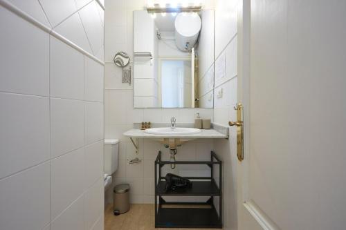 a white bathroom with a sink and a mirror at 53PAR389 - Magnifico piso en el centro de Poble Sec in Barcelona