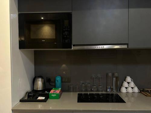 een keuken met een magnetron en een fornuis top oven bij Luxuria Studio Apartment in New Delhi