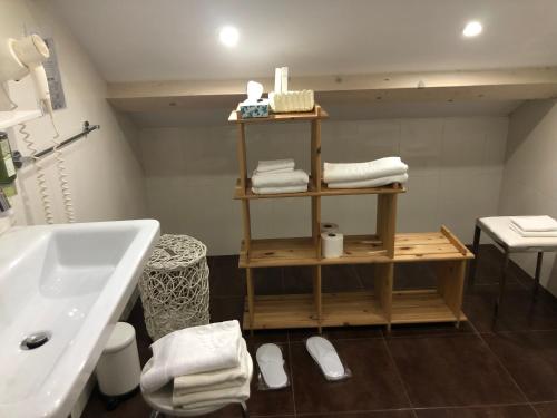 a bathroom with a sink and a shelf with towels at Villa Anica Dubrovnik in Dubrovnik