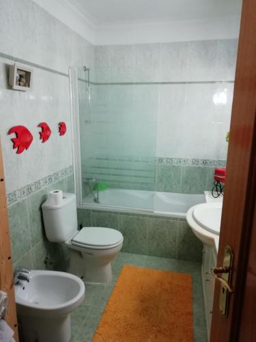 a bathroom with a toilet and a tub and a sink at Global Guest Rooms in Sintra