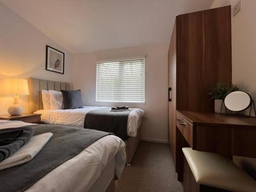 a hotel room with two beds and a window at The Luxurious Langdale 6 Lodge at Park Dean White Cross Bay, Lake Windermere in Windermere