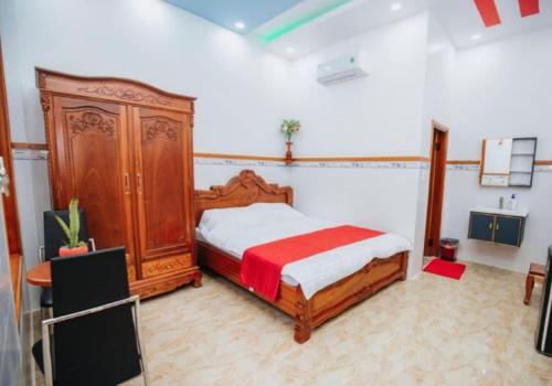 a bedroom with a wooden bed and a wooden dresser at VILLA GIÓ BIỂN LAGI - Villa Gia đình 4 Phòng Ngủ, Sức chứa 8 - 20 Khách, Cách Biển Cam Bình 700m di chuyển, Sân Vườn Rộng Rãi, Tiện Nghi Nướng BBQ & Bãi Đậu Xe Ô tô Miễn Phí in Lagi