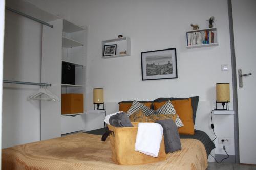 een slaapkamer met een bed met oranje kussens bij Dolce Vita Millau in Millau