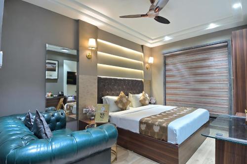 een slaapkamer met een groot bed en een leren bank bij Hotel Oak Plaza, New Delhi in New Delhi