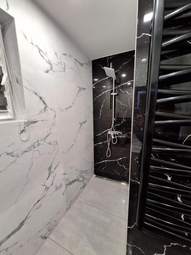 a bathroom with a black and white marble wall at Dom w Beskidzie - dla rodzin in Nowy Sącz