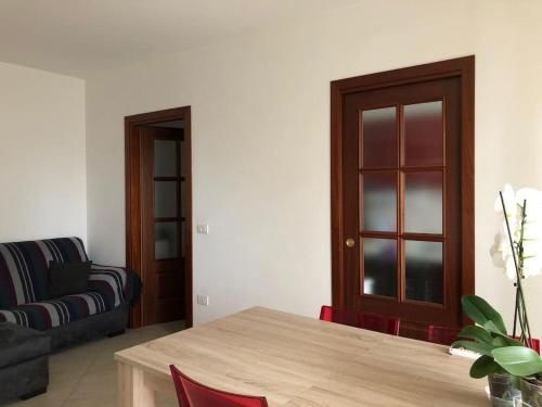 un soggiorno con tavolo e divano di Appartamento residenziale con posto auto privato a Sassari